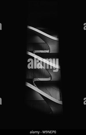 Beautiful greyscale shot of a spiral modern staircase shot from the side Stock Photo