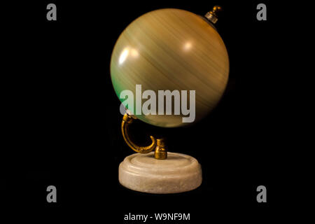 Antique Globe With a Gold Holder and marble stand , closeup , studiowork , black background , spinning around ,looks like pikture moves Stock Photo