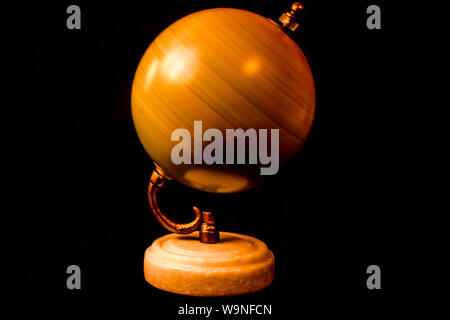 Golden Globe Spinning Around (not award) closeup on the black background Stock Photo