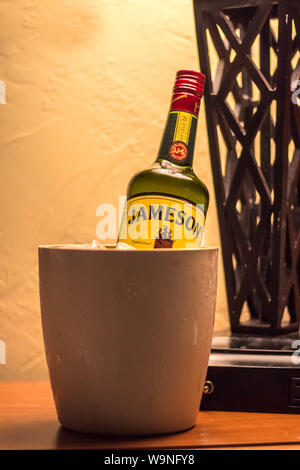 Jameson whiskey bottle in the can with ice under table lamp Stock Photo