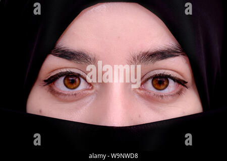 Muslim woman wearing red hijab veil, Afghan girl wear the burka or burqa, close up portrait photo Stock Photo