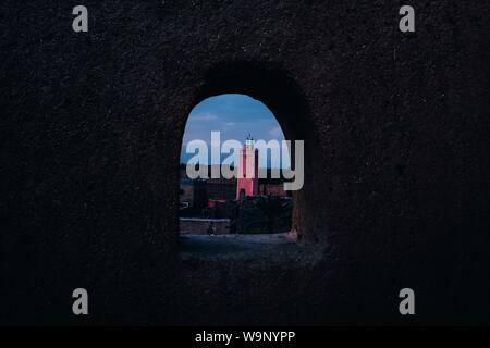 Tall red building shot from an arched type hole in the wall Stock Photo