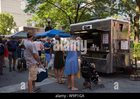 Hungry customers wait in line to order their lunch from the Head 2 Hock food vendor at Fort Wayne's Farmers' Market in downtown Fort Wayne, Indiana. Stock Photo