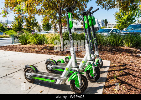 August 14, 2019 San Jose / CA / USA - Lime Electric Scooters parked near a public transit center in order to cover the last-mile; Lime is the brand na Stock Photo