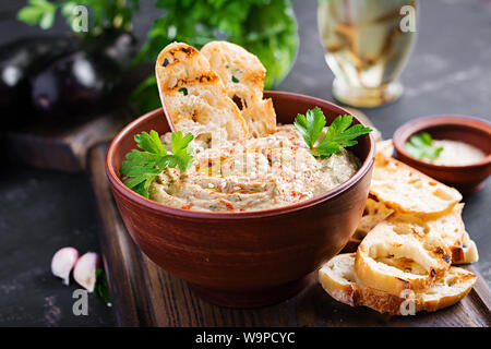 Baba ghanoush vegan hummus from eggplant with seasoning, parsley and toasts. Baba ganoush. Middle Eastern cuisine. Stock Photo