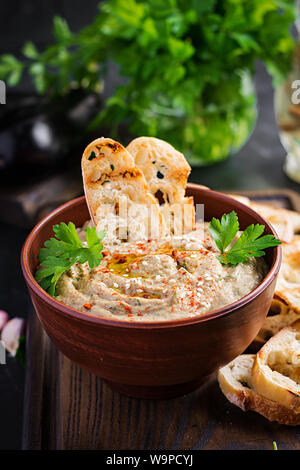 Baba ghanoush vegan hummus from eggplant with seasoning, parsley and toasts. Baba ganoush. Middle Eastern cuisine. Stock Photo