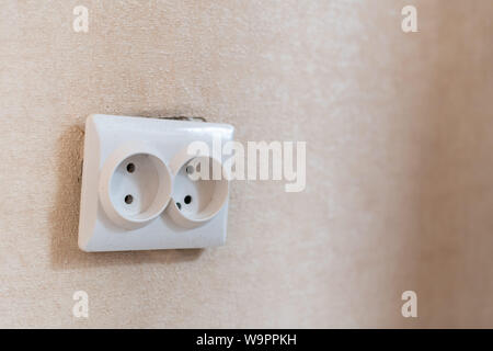 AC power double socket on wall, bad incorrectly installed, copy space. Socket for europlug type. Violations of safety standards. Fire-hazard. Stock Photo