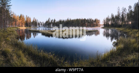 Beautiful panorama of sunrise view of a pond in Tiilikkajärvi National Park in Finland Stock Photo