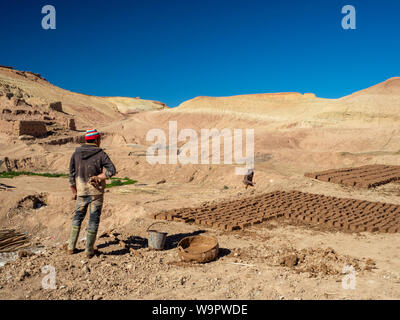 Morocco clay mud bricks makers, adobe brickworking workers, dry and wet wall stones. Traditional desert way of life, typical architecture Stock Photo