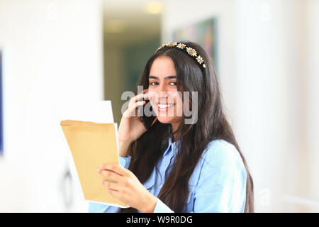 A young girl on the phone after getting her A Level exam results, UK 2019 Stock Photo