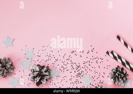 Christmas or New Year party decor on pink background, top view. Star shaped glitter, paper straws and other Stock Photo