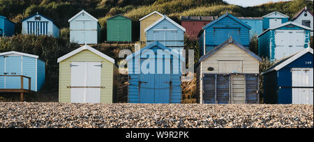 Panoramic view of colourful beach huts on a pebble beach in Milford on Sea, UK, selective focus, holiday concept.