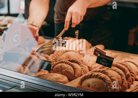 Lymington, UK - July 14, 2019: Cornish pasties on sale at a Mines A Pasty shop in Lymington, UK. Cornish pasty is a traditional British food particula Stock Photo