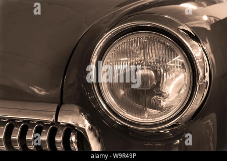 fragment of the front part of a vintage car, styled as an old photo with dust and noise Stock Photo