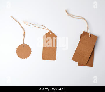 round and rectangular brown paper price tags hanging on a rope, white background Stock Photo