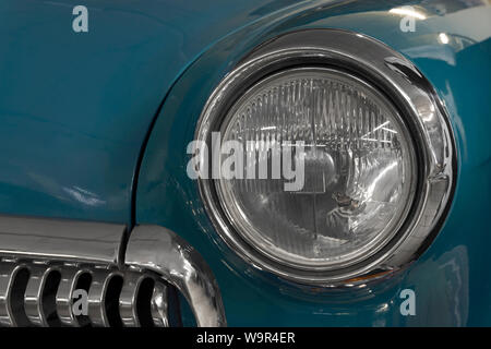 detail of the front part of a vintage car, headlight and radiator fragment Stock Photo