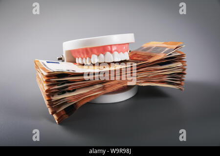 greediness concept - teeth model eating euro money bills Stock Photo
