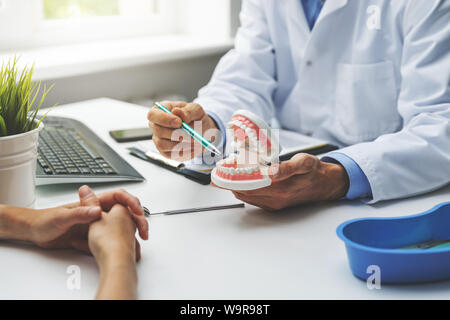 dentist and patient discussion about planned teeth treatment in dental clinic office Stock Photo