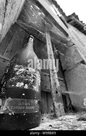 Village of Limeuil, France. Picturesque view of an empty wine bottle on the window sill of a derelict house. Stock Photo