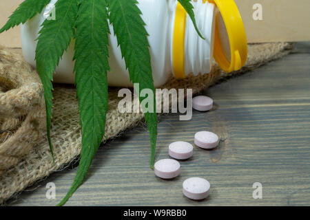 Conceptual types of cannabis products concept image with a cannabis leaf, scattered pills and pharmacy bottle Stock Photo
