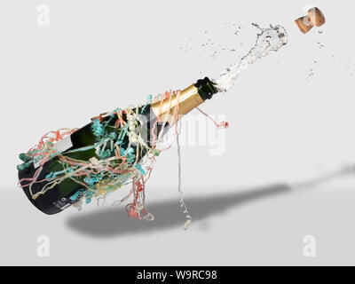 Champagne bottled festooned with streamers popping open, cork and drink fly out Stock Photo