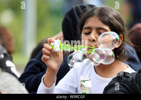 Bregana, Slovenia - September 20, 2015 : A Syrian girl playing by blowing bubbles on the slovenian border with Croatia. The migrants are waiting for t Stock Photo