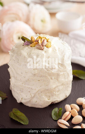 Delicate airy pistachio cake with frosting on black stone plate Stock Photo
