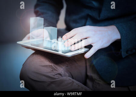 businessman interacts with hologram chart on a tablet Stock Photo