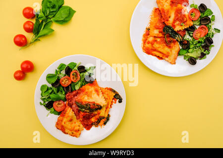 Italian Style Spinach and Ricotta Ravioli Meal With Black Olives anda Green Salad Stock Photo