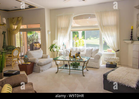 Modern Living Room With White Couch & Glass Coffee Table Stock Photo
