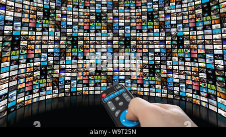 Image of large screen with many channels, hands of man with remote control. Stock Photo