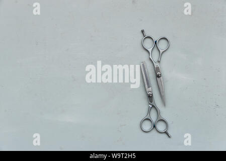 Pair of stylish professional barber scissors on gray wooden background. Copy space. Top view. Flat lay Stock Photo