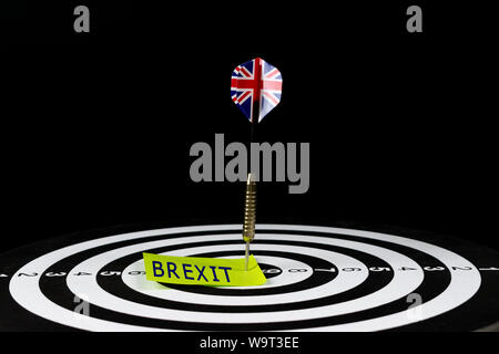 Flag of UK dart arrow hitting in the target center of dart board with text "BREXIT". Stock Photo