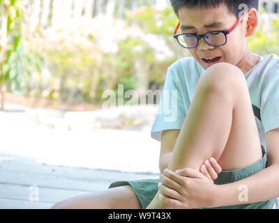 Asia boy feel knee pain after play. healthy problem concept. Stock Photo