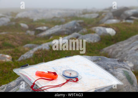 Close-Up Of Navigational Compass With Whistle And Map on a Scottish hill in the fog. Stock Photo