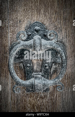 An old classic cast iron Knocker on a wooden door. Stock Photo
