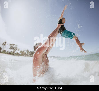 Father throwing his son in the air in the ocean, Hawaii, United States Stock Photo