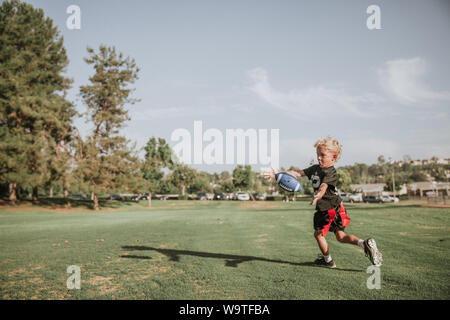 Boy playing flag football, catching a ball, California, United States Stock Photo