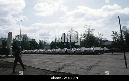 9th May 1993 During the Siege of Sarajevo: a Ukrainian soldier strides towards BTR-80 APCs parked in the parade ground of Tito Barracks. As part of the United Nations Protection Force (UNPROFOR), they are about to depart to offer protection to the Bosnian Muslim enclave of Žepa, 40 kilometres east of Sarajevo. Stock Photo