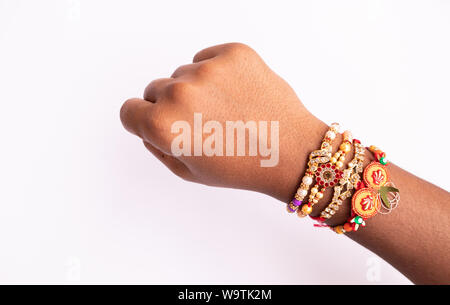 Indian festival Raksha Bandhan, raki or Raakhi on hand on isolated background. Stock Photo