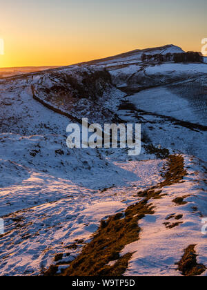 The sun sets over Green Slack Hill and Peel Crags on Hadrian's Wall in Northumberland. Stock Photo