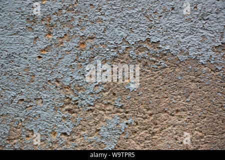 Light blue paint flaking off terracotta-coloured wall Stock Photo