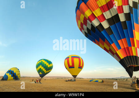 Teotihuacan, Mexico - April 6, 2019 : Colorful hot air balloons about to take off at dawn in rural field with blue sky near the town of Teotihuacan, M Stock Photo