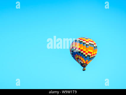 Colorful hot air balloon taking off with blue sky and copy space Stock Photo