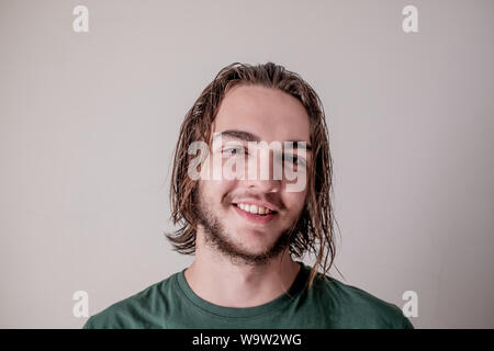 Young attractive guy or boy smiling face expression with wet hair and beard, young man portrait photo Stock Photo