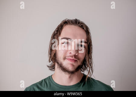 Young attractive guy or boy smiling face expression with wet hair and beard, young man portrait photo Stock Photo