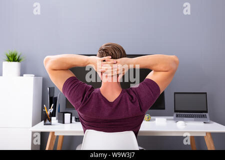 Close-up Of Businessman With Hands Behind Head Relaxing On Chair Stock Photo