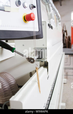 Side view on single sided automatic edge banders in private furniture workshop, selective focus Stock Photo