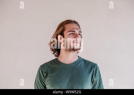 Long haired blonde man looking right, handsome bearded young guy turn the right Stock Photo