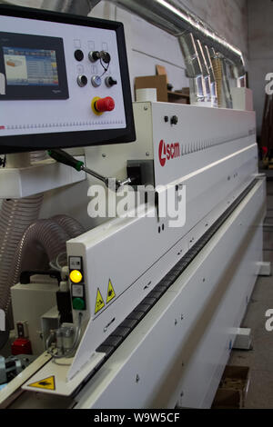 Kharkiv, Ukraine - July 12, 2016: Side view on single sided automatic edge banders in a private furniture workshop, selective focus Stock Photo